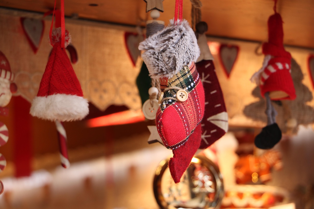 Jouluinen sukka, tonttu ja tonttulakki roikkumassa.