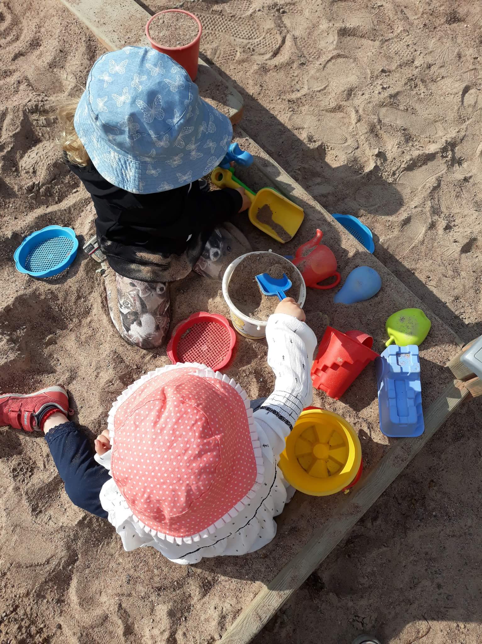 Lapset leikkivät hiekkalaatikolla.