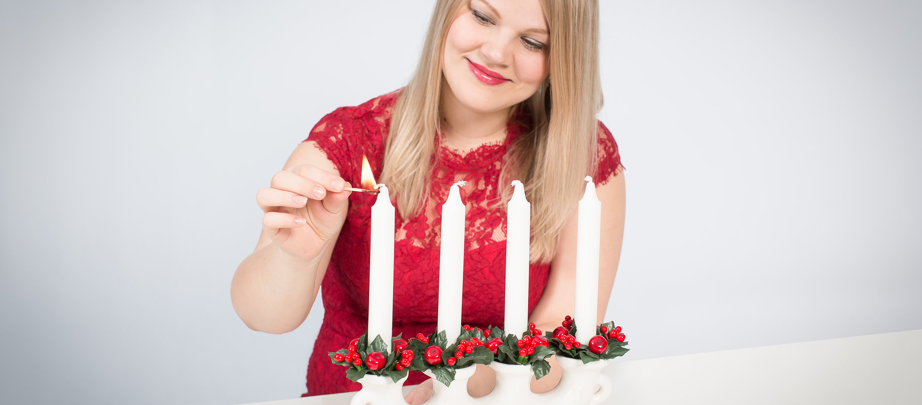 Nainen sytyttää adventtikynttilän