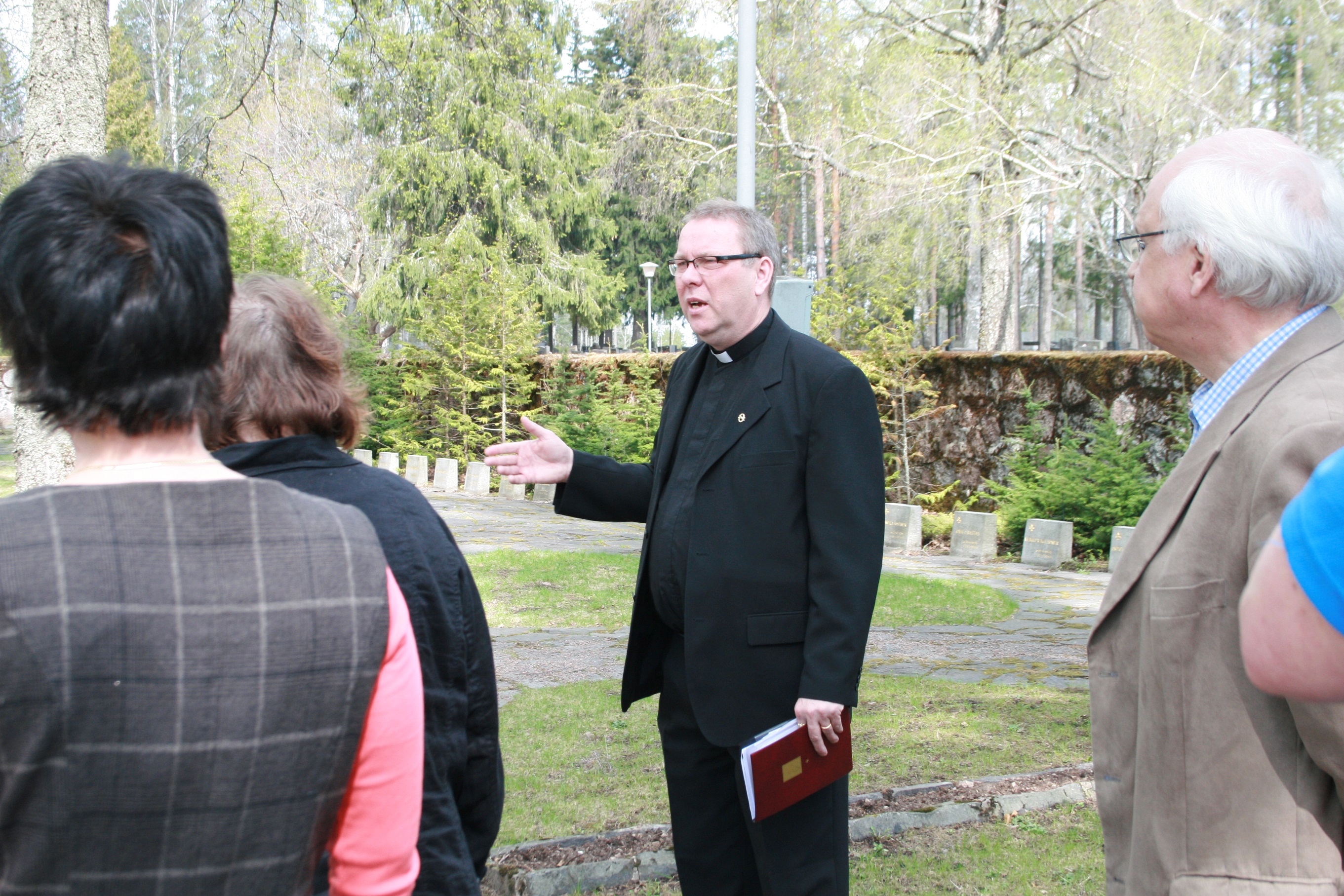 Keijo Gärdström hautausmaalla opastettavan ryhmän kanssa.