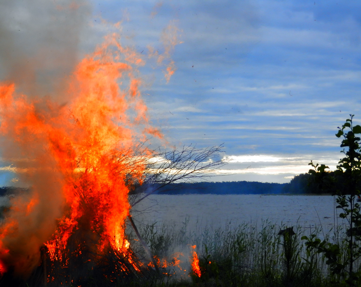 Juhannuskokko palaa järven rannalla.