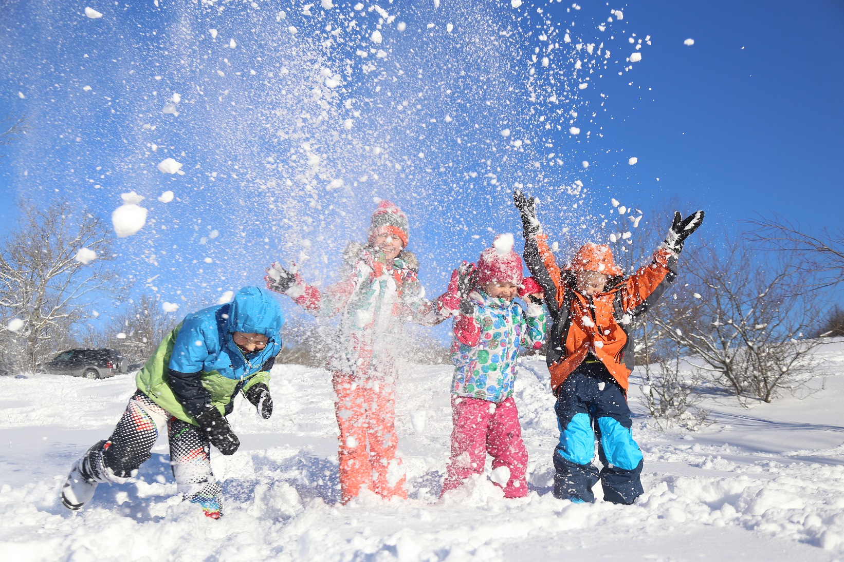 Lapset heittävät lunta ilmaan.