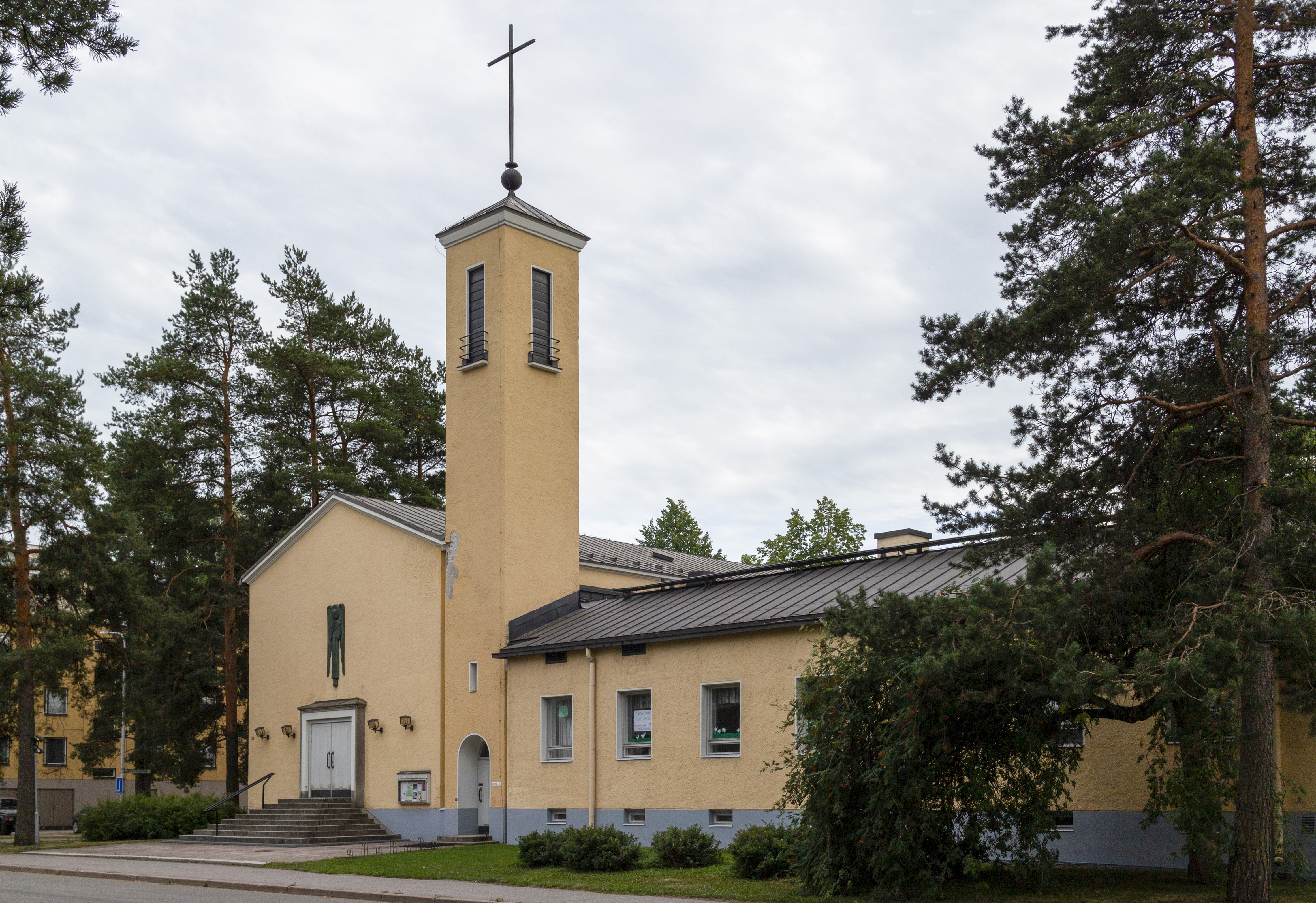 Käpylän keltainen kivikirkko ulkoa kuvattuna.