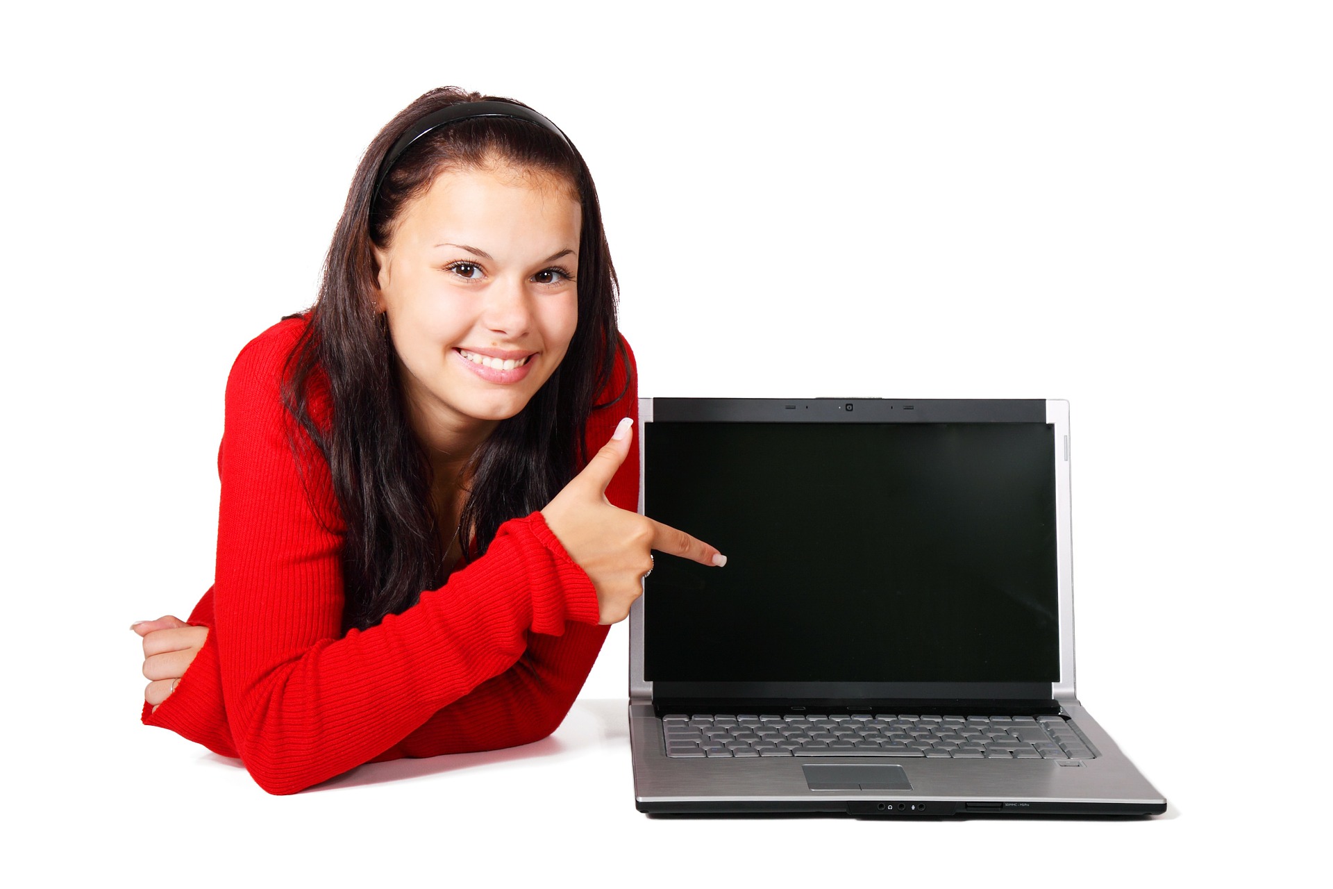 Nuori nainen hymyilee kannettavan tietokoneen vieressä.