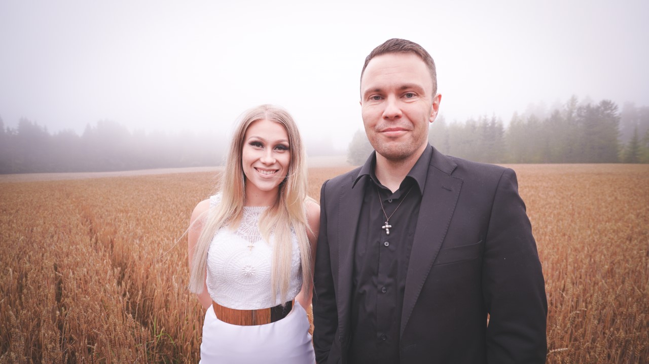 Kaksi artistia, Kristiina Brask ja Ossi Jauhiainen, taustalla viljapelto.