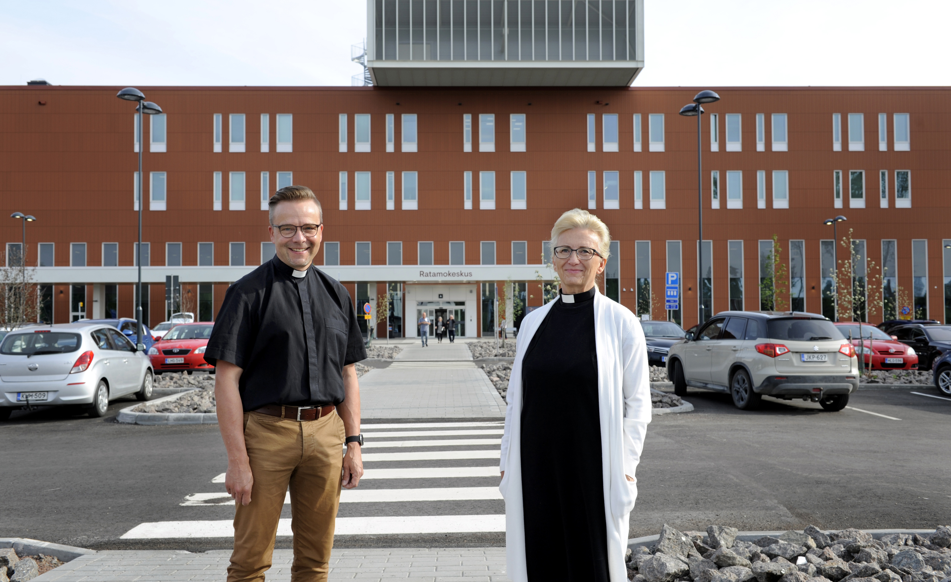 Sairaalpapit Kari Niemelä ja Tuula Ylikangas seisovat uuden Ratamokeskuksen edessä hymyillen kameralle.
