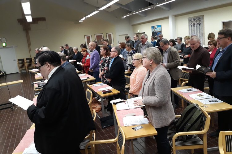 Kokouksen osallistujat laulavat yhdessä virttä.