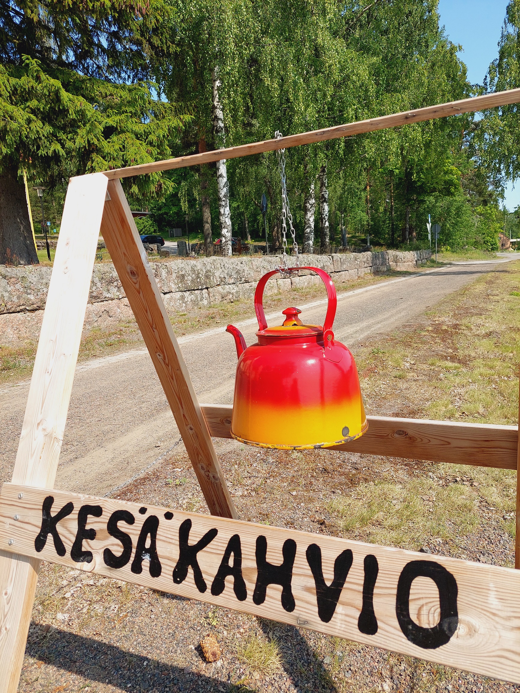 Kahvipannu roikkuu telineessä tien laidassa.