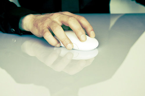Kuvassa näkyy henkilön käsi, joka käyttää tietokoneen hiirtä.